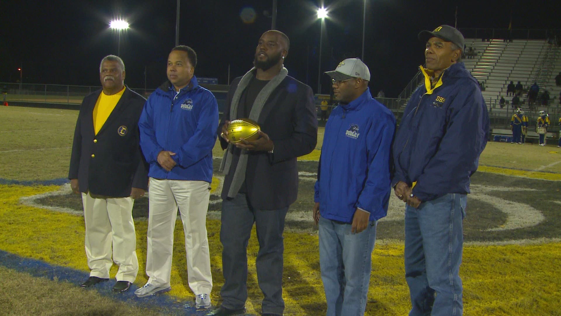 DeMario Pressley presents game ball at alma mater Dudley High School in Greensboro.