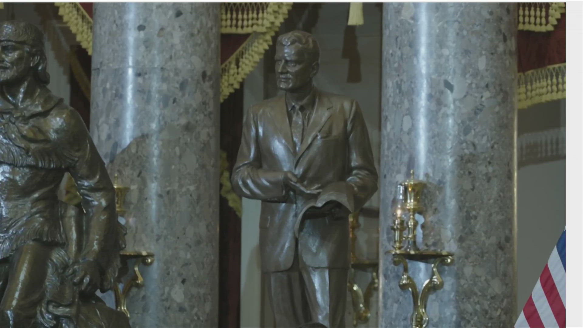 The sculpture depicts Graham gesturing toward an open Bible in his hand.