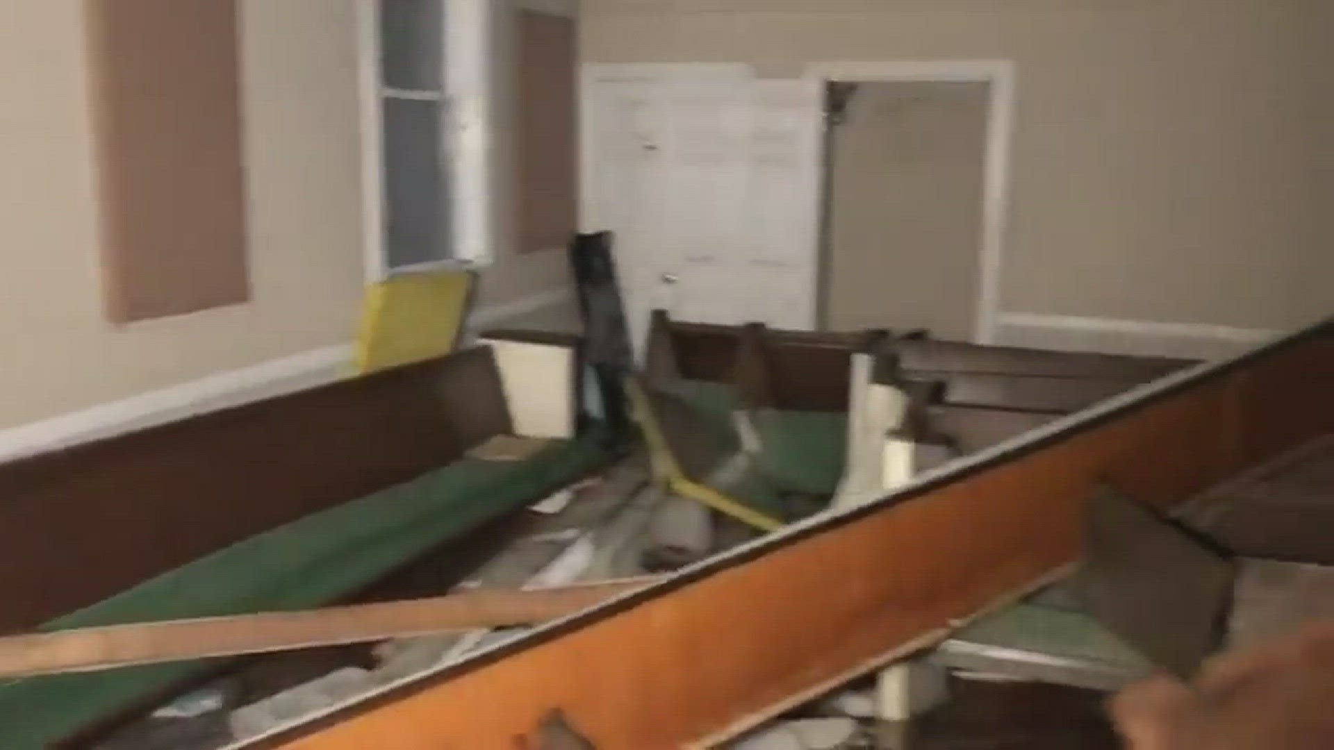 A cross remains on the wall after a church was hit by a tornado in Greensboro
