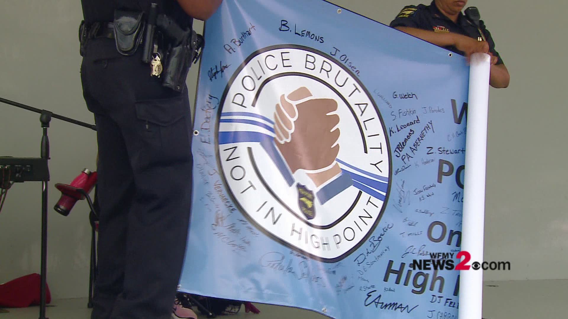 High Point police officers signed a banner condemning police brutality at a protest along with citizens.