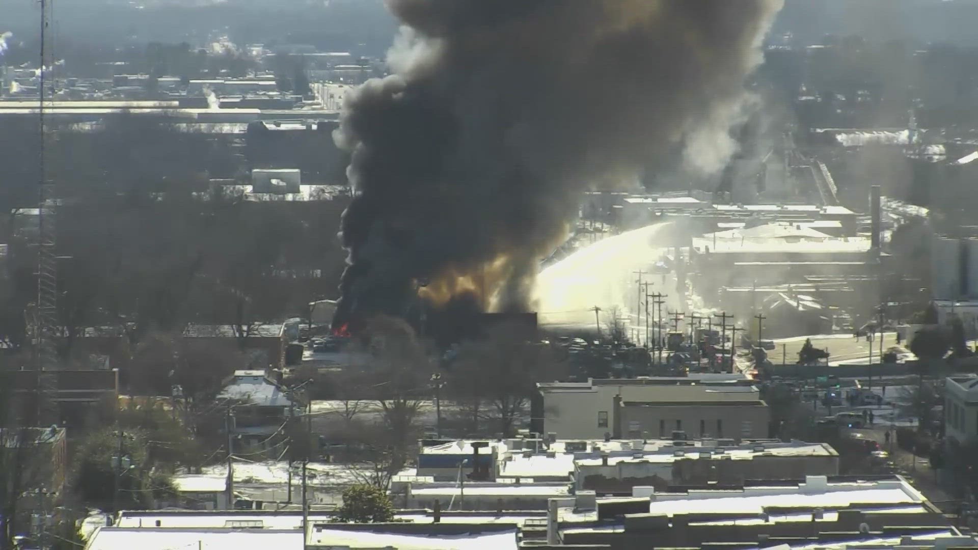 A fire started when an auto body shop worker dropped a light onto leaking fuel.