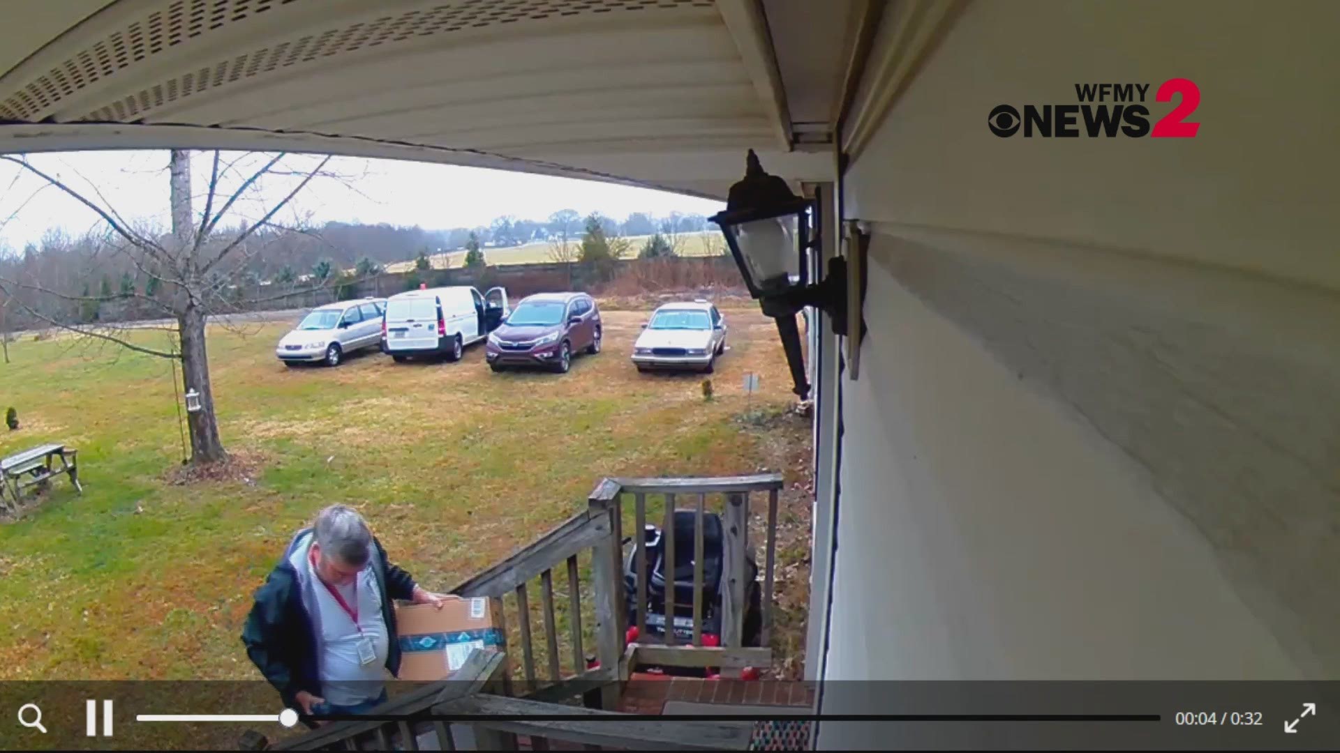 The video shows the US postal service employee carefully walking up the doorstep and placing the package in a plastic bag, likely to protect it from the rain.