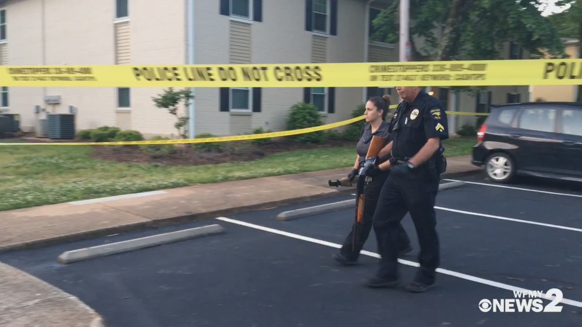 Police bring out a gun while searching for evidence at a High Point apartment complex Monday morning.