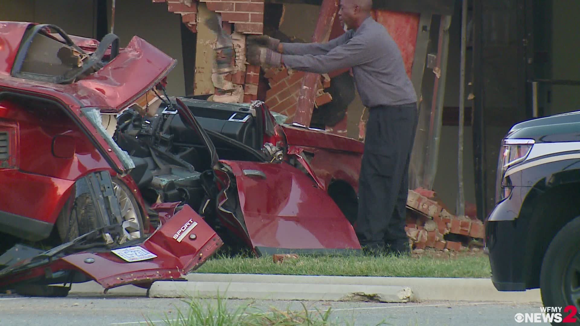 Crews work to clean up the wreckage after a man drove an SUV into a building in Greensboro Monday morning.
