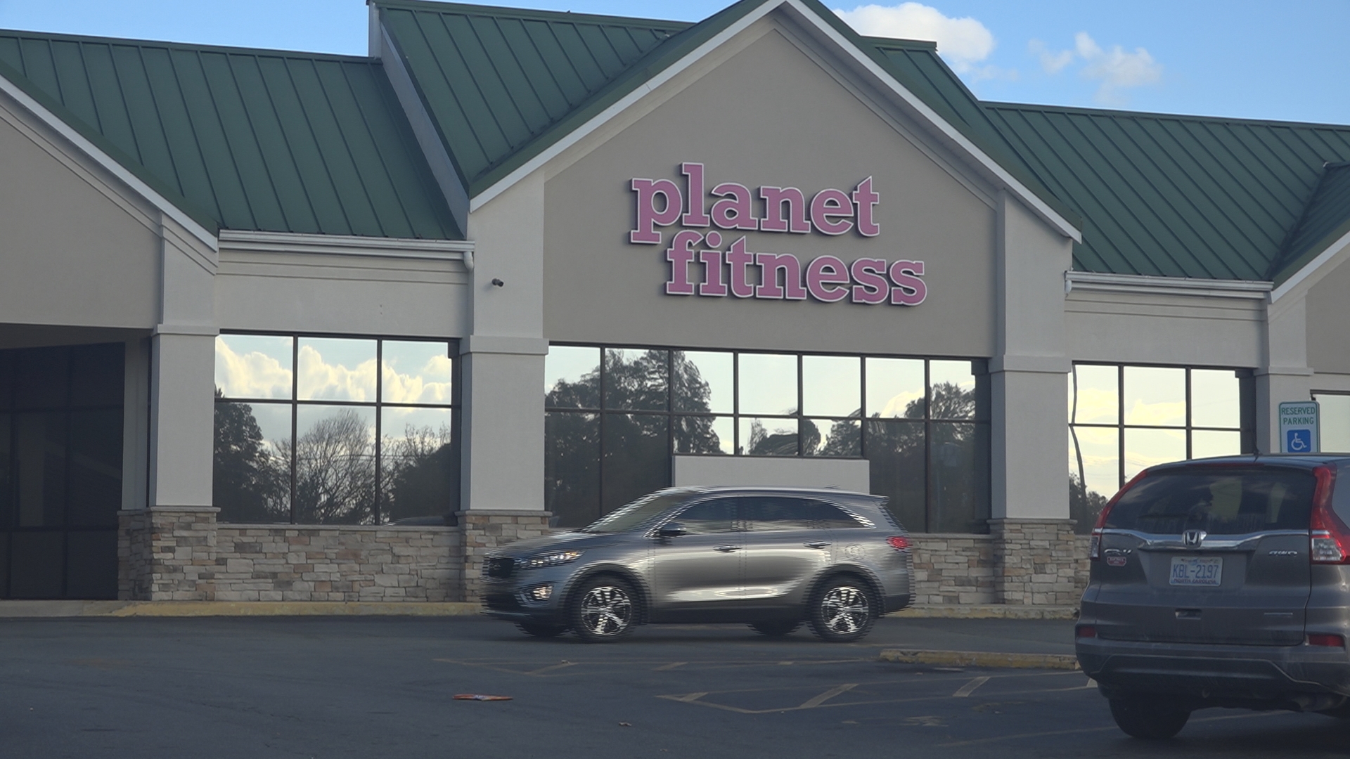 Police say three men held someone at gunpoint and then stole their car in a Planet Fitness parking lot.