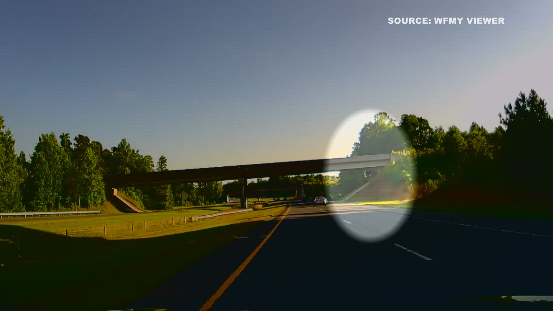 A video showed a driver go up an embankment, and nearly miss colliding with an overpass.