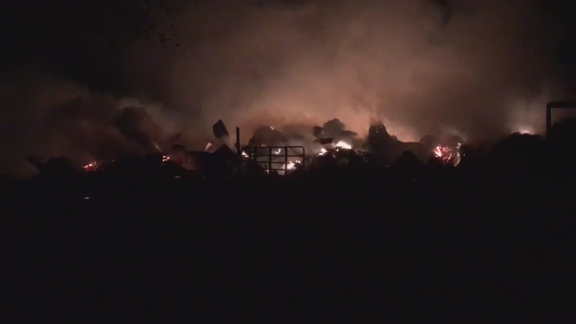 Firefighters say 300-500 bails of hay are burning inside the barn.